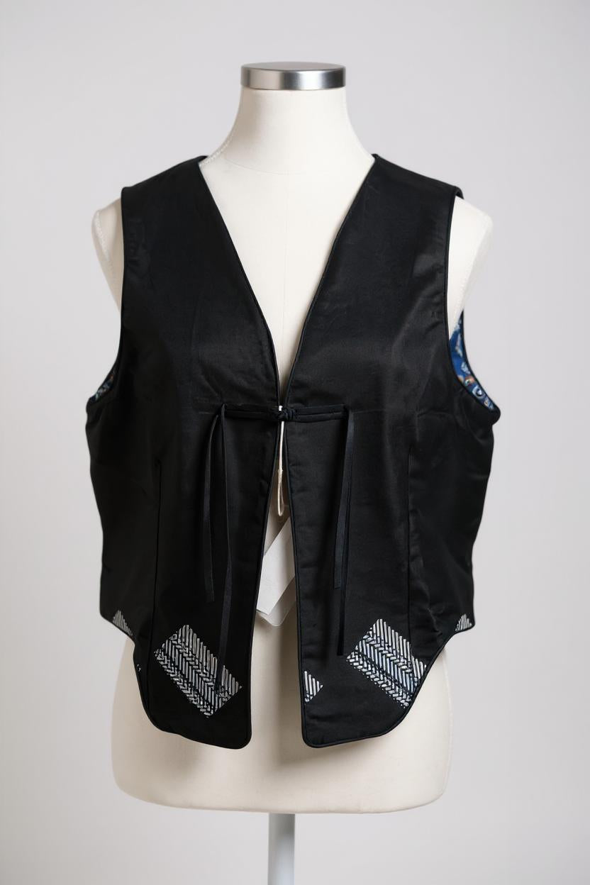 Black Song Brocade vest with V-neck, front tie closure, and white geometric hem details