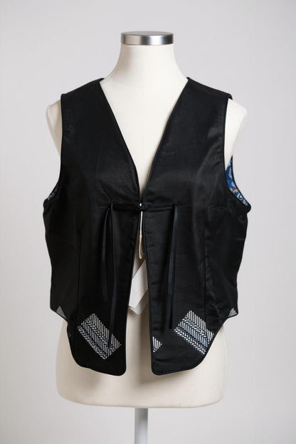 Black Song Brocade vest with V-neck, front tie closure, and white geometric hem details