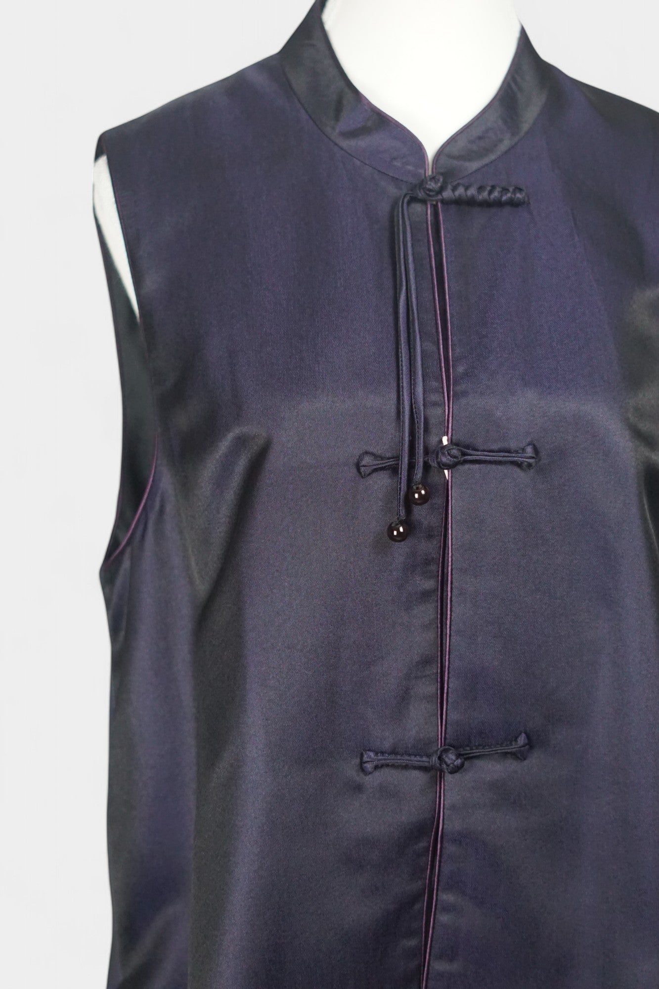 Women's dark purple Song Brocade vest with a mandarin collar, purple piping, and traditional frog buttons with tassels.