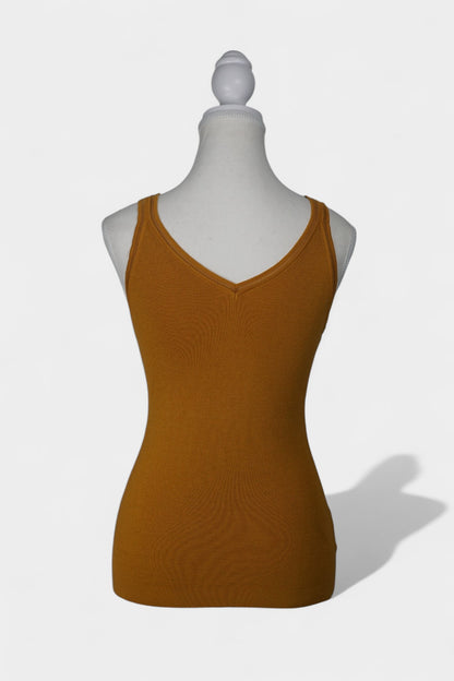 Rear view of a mustard-colored knit tank top on a white mannequin, featuring wide straps and a clean V-shaped neckline at the back.